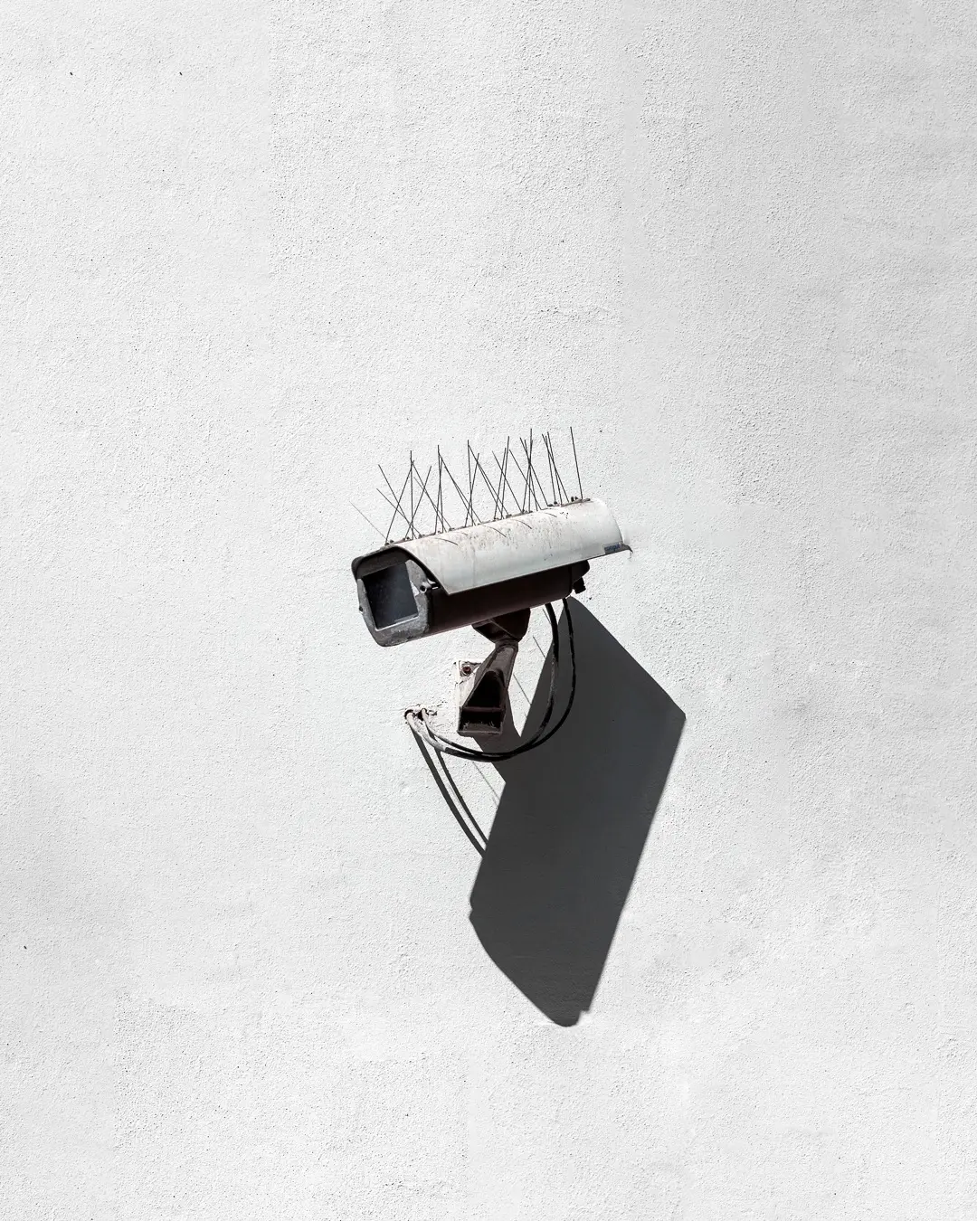 Security camera mounted on a white building wall
