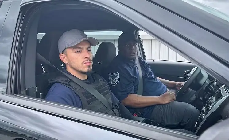Two Blu Wing guards in a patrol vehicle