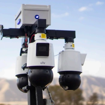 Camera tower with three PTZ cameras and a status light against the sky